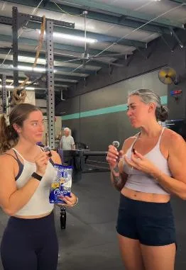 Two people snacking on prunes at the gym