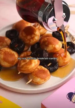 Syrup poured over mini pancakes and prunes