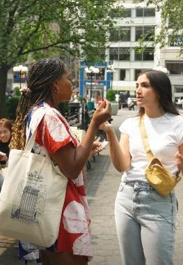 Two friends sharing prunes on a city street